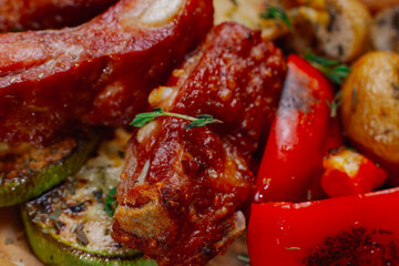 fresh beautiful smoked ribs with grilled vegetables All this is on a wooden tray. healthy vuks food. meat macro photography
