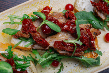 Appetizing sandwiches with meat, greens and berries on a plate.Snack for alcoholic drinks....