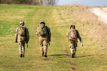 two male and a female British army infantry soldiers on a tab tabbing exercise