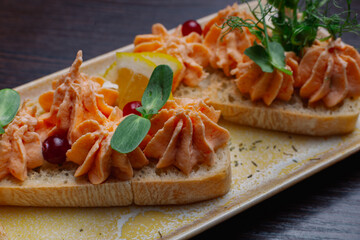 White bread sandwiches with fish cream and herbs on a white plate. appetizer for wine. beautiful design of the dish. new trend. appetizing look