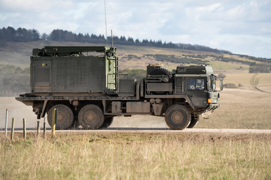 British army MAN SV HX 60 6x6 18.330 platform truck, loaded with a specialist container, in action on a military exercise