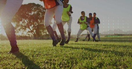 Young athletes playing soccer on grass field with digital data overlay animation - Powered by Adobe