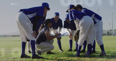 In blue uniforms, baseball team huddling around coach with clipboard on field