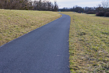 asphaltierter Ragweg an einem Damm