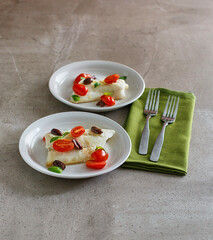 Greek style sea bass topped with cherry tomato and kalamata olives