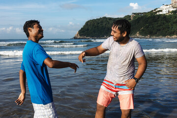 two Latin best friends men having fun at beach in Acapulco Mexico Latin America, hispanic young...