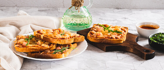 Baked toasts with bacon, cheese and tomato sauce on a plate on the table web banner