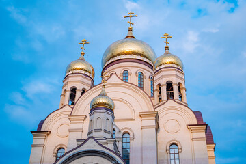 Golden domes of a russian orthodox church gleaming against a vibrant blue sky, showcasing religious...