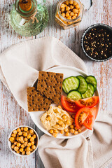 Vegetarian plate with chickpeas and vegetables on the table top and vertical view