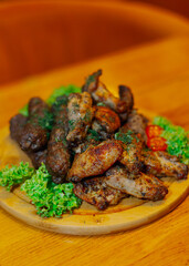 Fried wings, fried sausages and grilled meat all on one wooden tray with vegetables. close-up