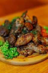 Fried wings, fried sausages and grilled meat all on one wooden tray with vegetables. close-up. snack for beer