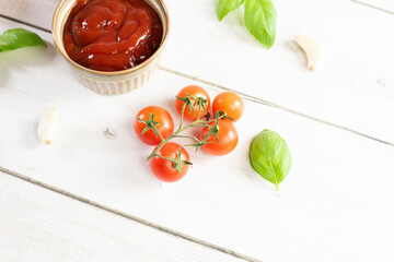 Tomato paste, sauce, ketchup and cherry tomatoes on branches and basil