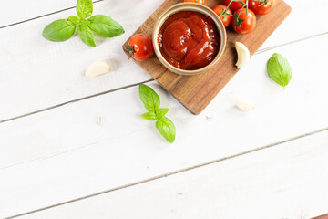 Tomato paste, sauce, ketchup and cherry tomatoes on branches and basil