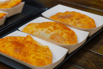 Ready Chebureks in the package lie on a tray and wait for their client with a delicious dish for all ages