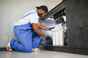 Plumber installs or change water filter. Replacement aqua filter. Repairman installing water filter...
