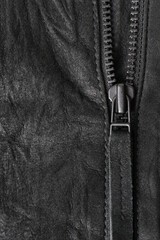 Crumpled black suede textured vertical background with black metal zip
