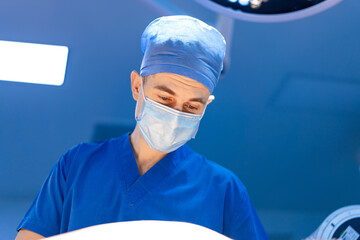 Surgeon prioritizes patient care. A skilled surgeon in scrubs and a mask attentively examines a...