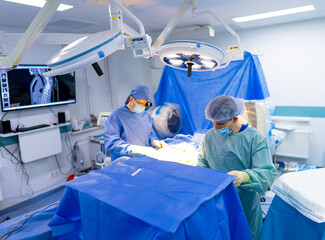 Surgeons operating in modern facility. Two surgeons focus on a surgical procedure in a sterile...