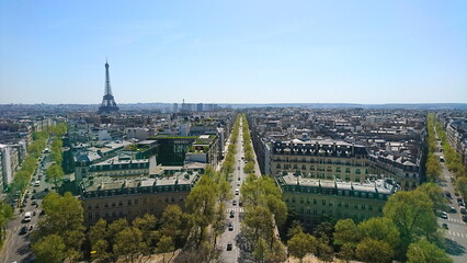 Aerial view of Parisian streets lined with trees, bustling traffic, and the iconic Eiffel Tower