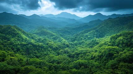 Naklejka premium Lush green mountains stretch across the horizon under a cloudy sky, creating a serene and tranquil natural landscape.