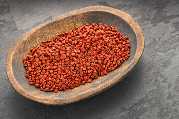 Organic red annatto seeds in the bowl - Bixa Orellana