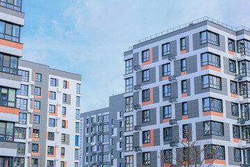 Fototapeta premium The concept of modern architecture, residential complex, apartment buildings for living. Multi-storey, apartment buildings of the residential complex in a single architecture in gray and white tones