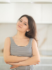 Fototapeta premium Young positive woman housewife standing in kitchen at home