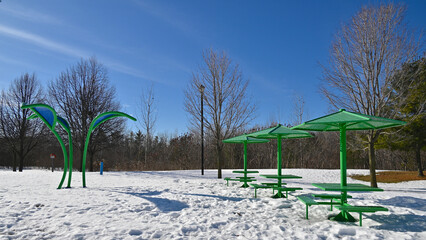 Park bench in the playground of the public park in winter