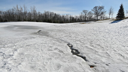 Dramatic wide-angle view of  breaking up of ice surface in the park.