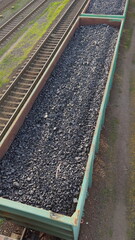 Naklejka premium Open wagon transporting coal along railway tracks