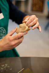 Obraz premium Professional male potter making clay figure for medieval popular strategy board game - tafl. Handwork, crafting and traditional arts concept