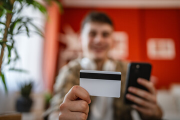 young man enjoy at online shopping on mobile phone at home
