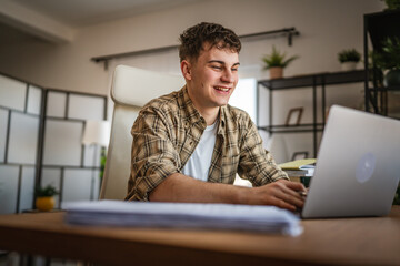 young man student learn and prepare exam from notebook and laptop