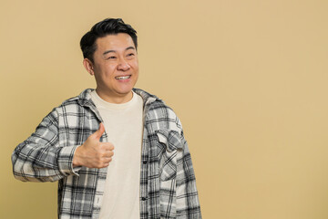 Like. Asian man raises thumbs up agrees with something or gives positive reply recommends...