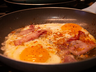 frying pan with bacon and eggs