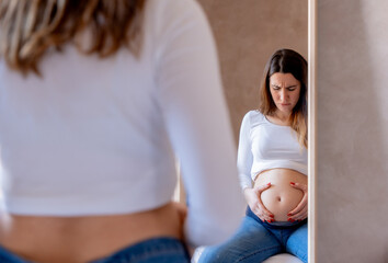 A pregnant woman concerned about the discomfort of her pregnancy belly