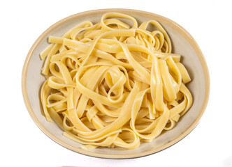 A dish of cooked  fettuccine or linguini pasta isolated on white