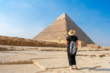 Back view of woman looking at Great Pyramids of Chephren and Cheops, Cairo, Egypt. Two of the three Great Pyramids, Giza pyramid complex (Giza Necropolis)