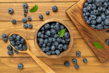 Bowl with fresh bright blueberries on wooden background,top view