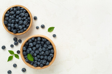 Bowl with fresh bright blueberries on concrete background,top view