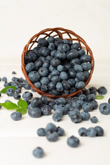 Bowl with fresh bright blueberries on wooden table