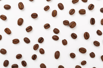 Roasted coffee beans with leaves on white background,top view