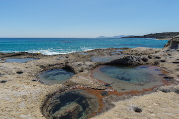 Holes of petrified tree filled with seawater at Geopark of Agios Nikolaos a Petrified Forest at mediterranean sea, Laconia, Peloponnese, Greece