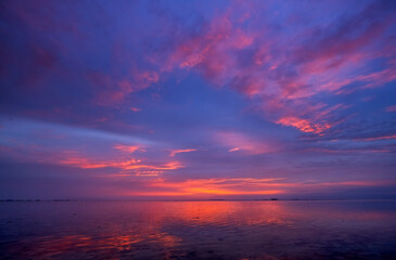 Vibrant sunset over the calm sea reflecting colorful skies