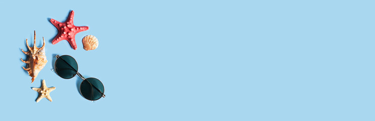 Summer time vibes, minimal coposition with set of sunglasses, starfish and sea shells on blue...