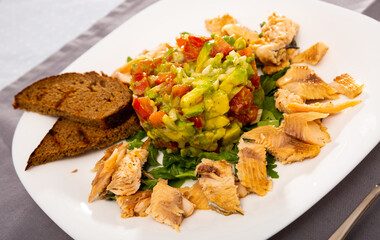 Delicious fried trout fillets with fresh guacamole salad and crispy rye croutons