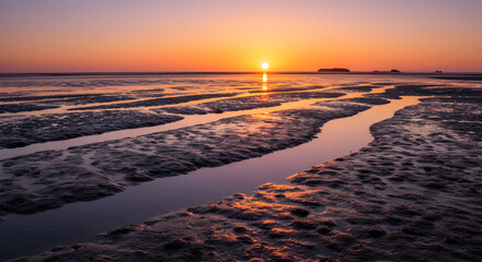 Sunset Reflection Over Mudflats Creating Serene Beach Landscape Scenery