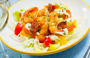 Seafood dish. Delicious salad of grilled shrimps with chorizo, tomatoes, lettuce, onion and citrus with delicate cream sauce