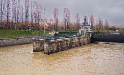 Manzanares river floodgates releasing water in madrid, spain
