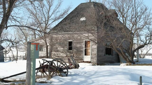 small abandoned house in the field covered with snow